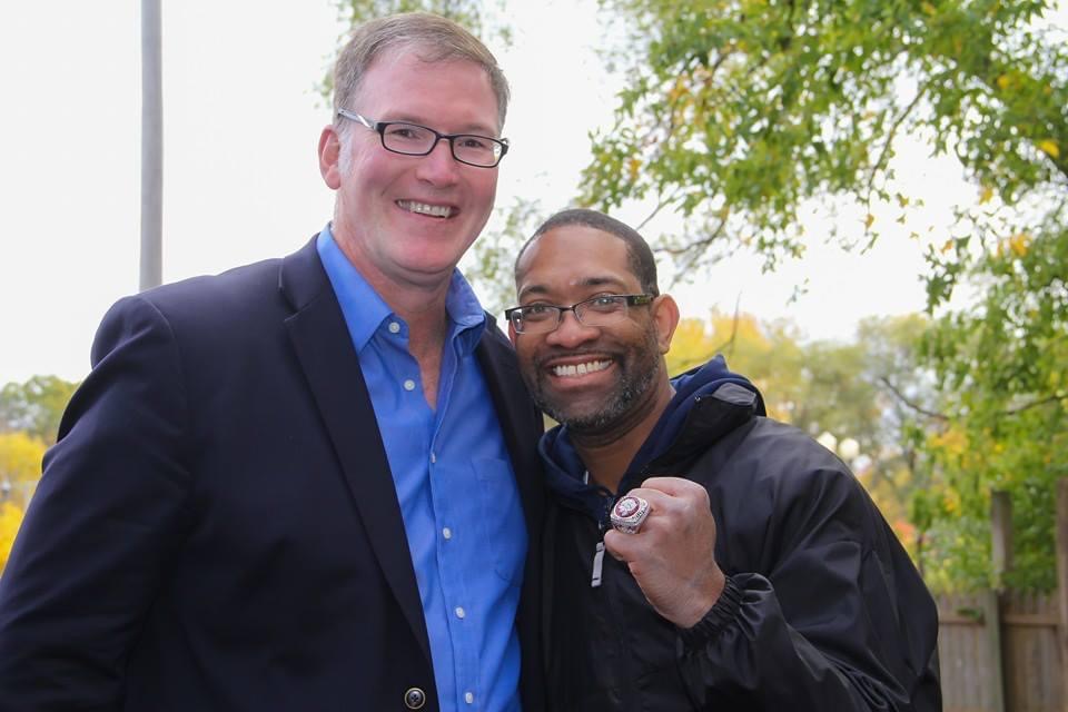 DJ Holland wearing a Blackhawks championship ring beside Jim Cornelison at a veterans event