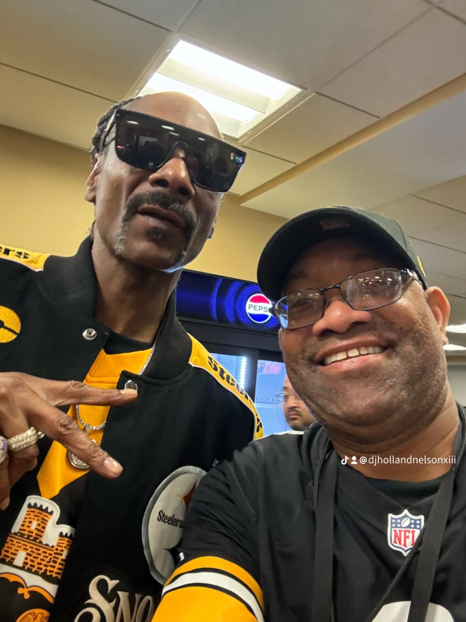 Two people posing in black-and-gold sportswear in a game-day snapshot