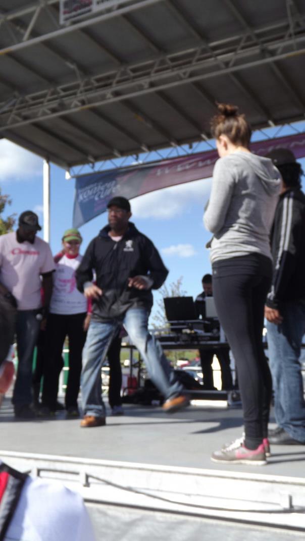 DJ Holland onstage during a large outdoor community event